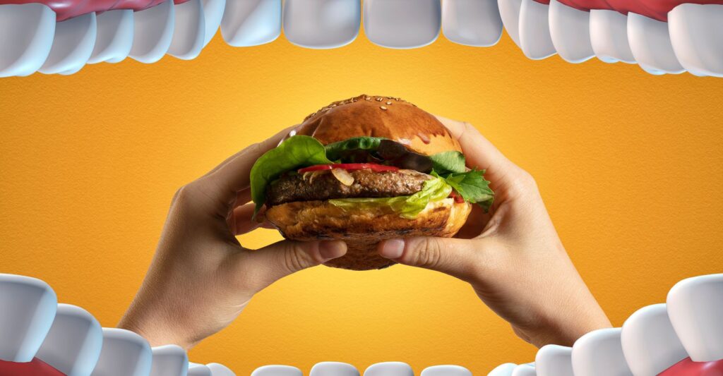 Taking bite of a burger from view of inside mouth
